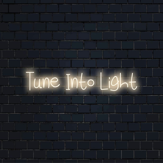 Tune Into Light Neon Light with neon text light against black brick wall