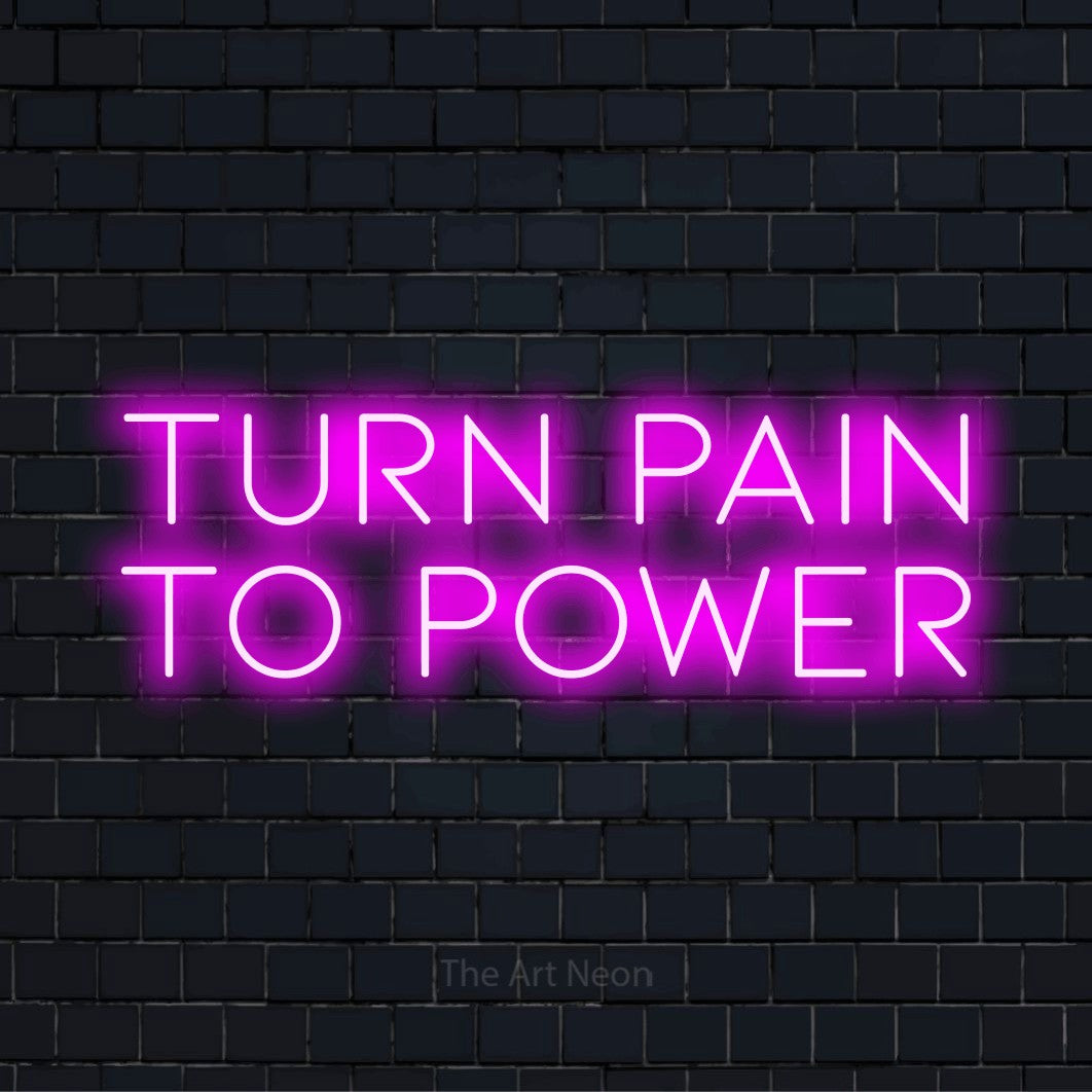 "Turn Pain To Power" script-style LED neon sign on a black brick wall