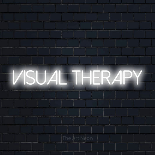 "Visual Therapy" glowing LED neon sign on a black brick wall