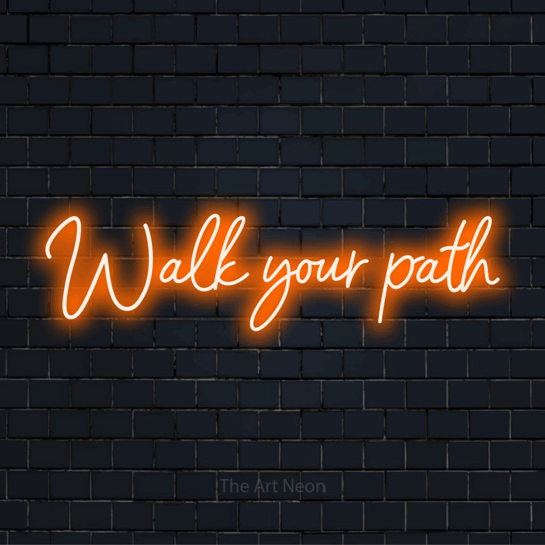 "Walk Your Path" LED neon sign on a black brick wall