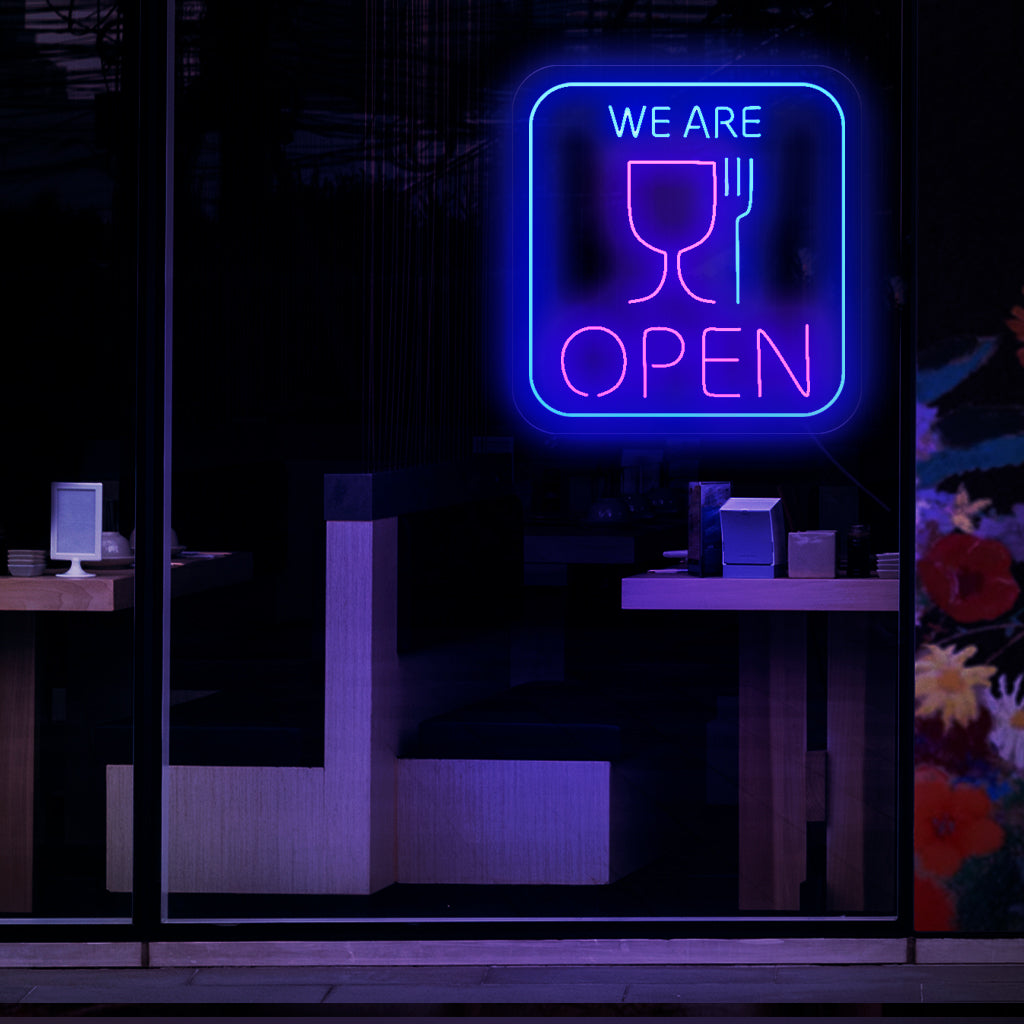 Ein fesselndes Neonschild mit den Symbolen einer Tasse und einer Gabel, das anzeigt, dass ein Restaurant oder Lokal geöffnet ist.