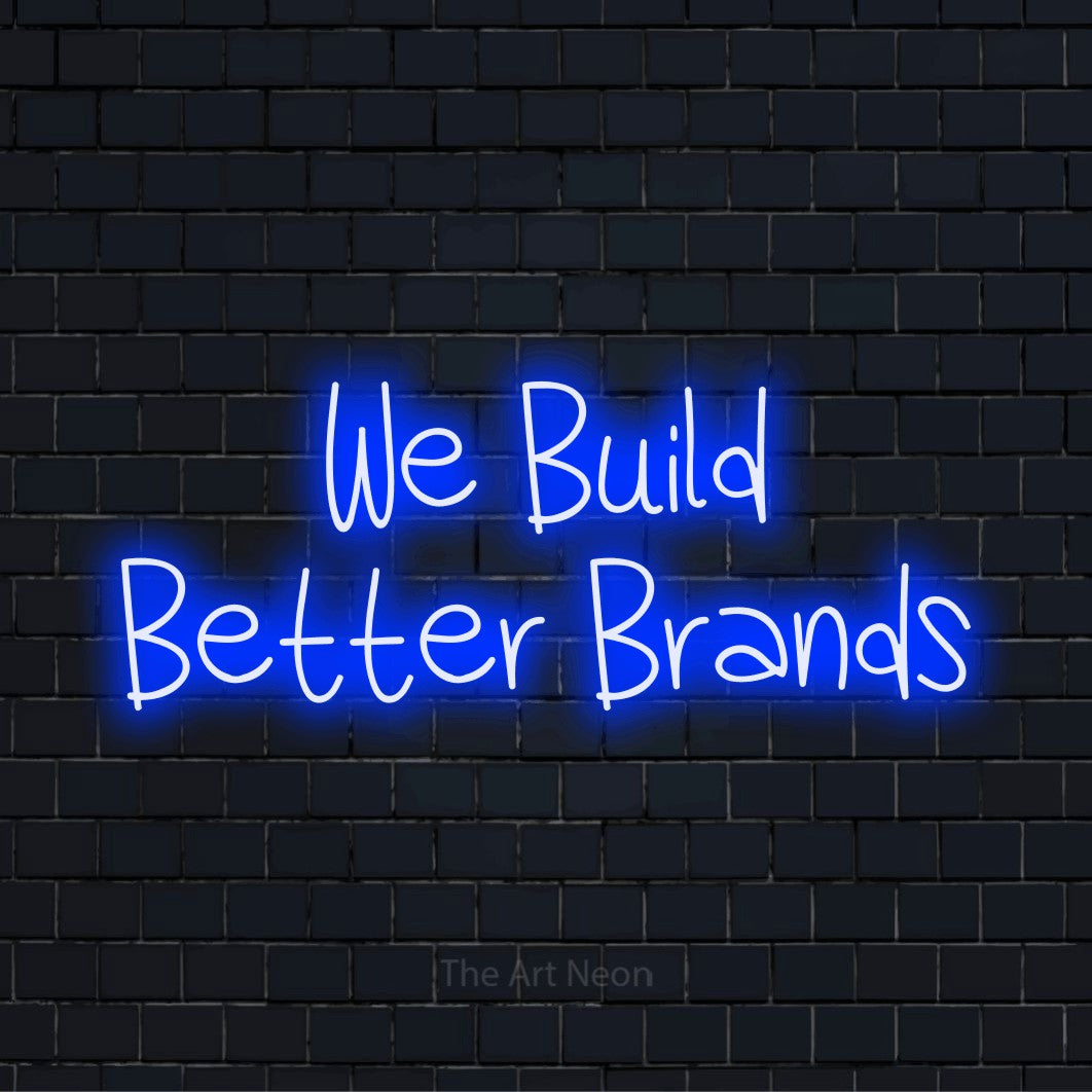 "We Build Better Brands" script-style LED neon sign on a black brick wall
