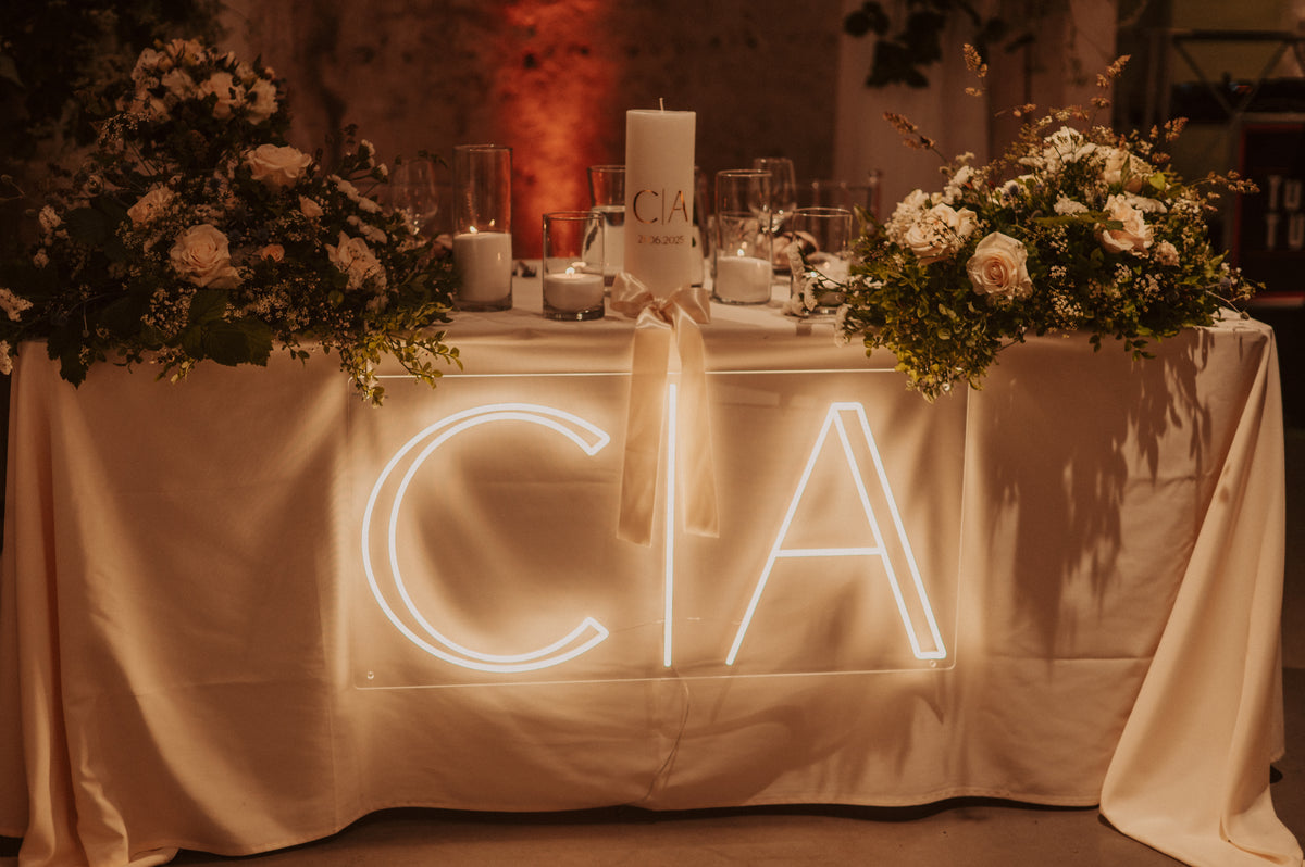Individuelles LED-Neonschild mit Initialen, mit Blumen und Kerzen bei einer Hochzeitsfeier dekoriert