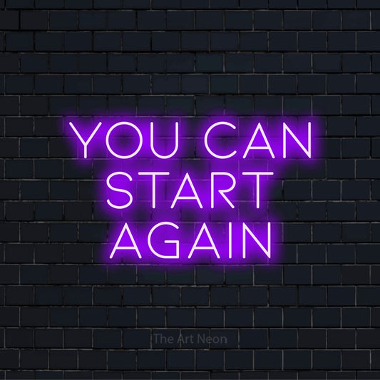 "You Can Start Again" text design with neon effect on a black brick wall