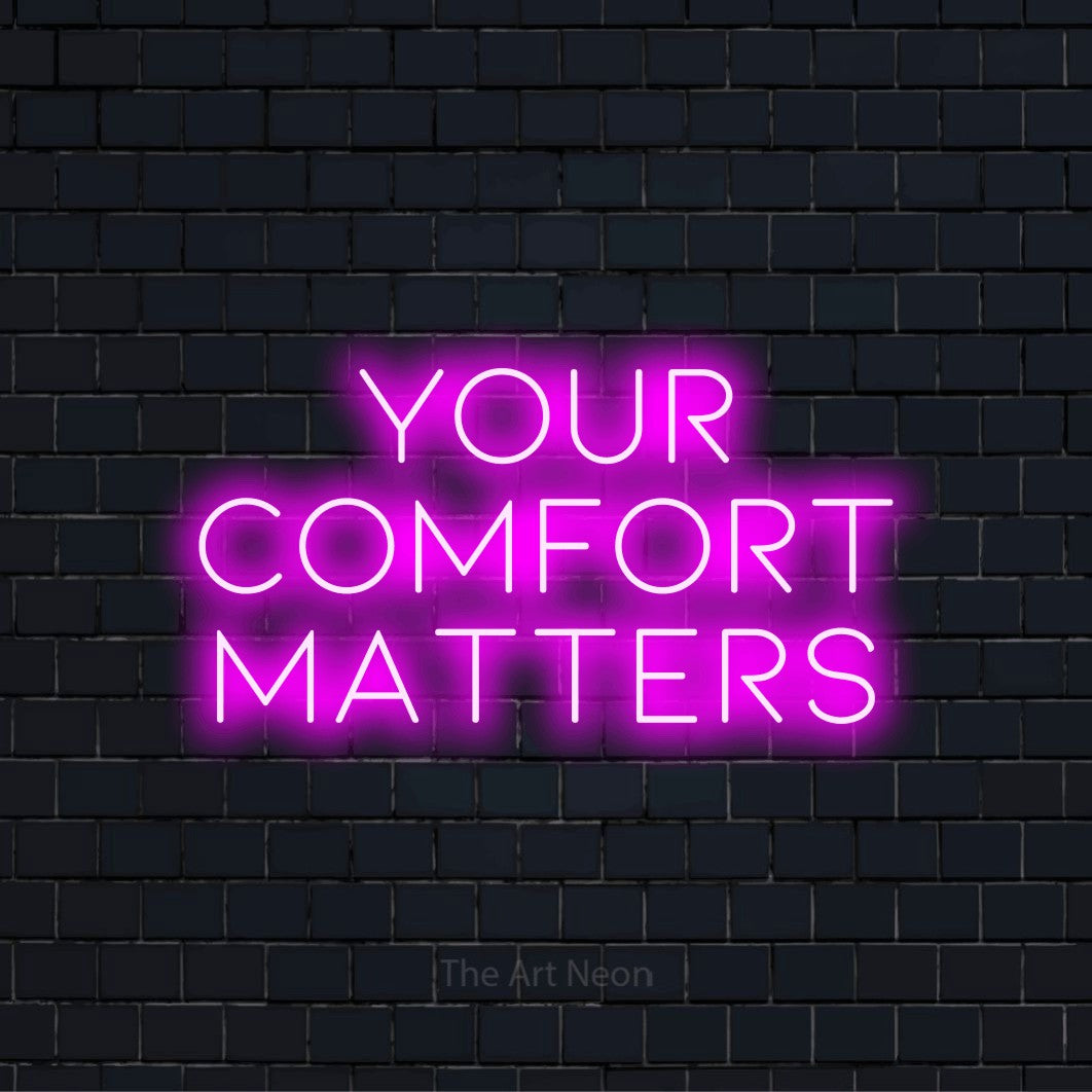 "Your Comfort Matters" script-style LED neon sign on a black brick wall