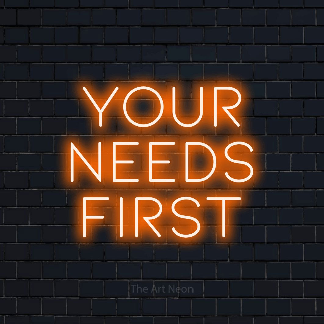 "Your Needs First" LED neon sign on a black brick wall