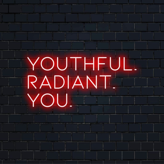 Youthful Radiant You Neon Sign, soft neon glow against brick backdrop